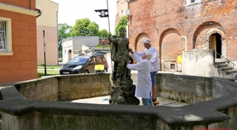 Oczyszczają kopię rzeźby kobiety